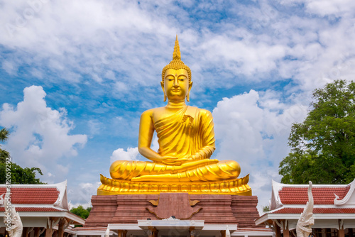 Beautiful  Big Golden Buddha statue against blue sky in Thailand temple khueang nai District  Ubon Ratchathani province  Thailand.Amazing Buddha image with sunny sky clouds.