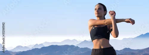 Fototapeta Młoda szczupła wysportowana dziewczyna w odzieży sportowej z nadrukami skóry węża wykonuje zestaw ćwiczeń. Fitness i zdrowy styl życia.