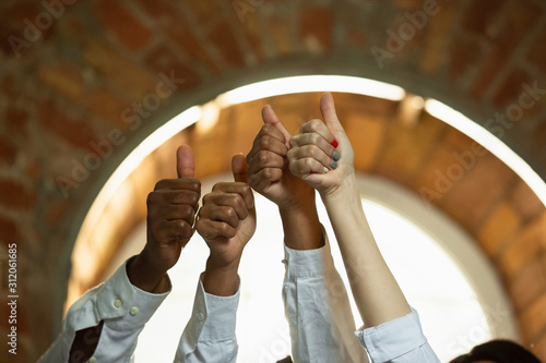 Close up of african-american and caucasian human's hands gesturing. Gesture of nice, good. Business, teamwork, studying, education, ad, finance, love and relationship, family concept.