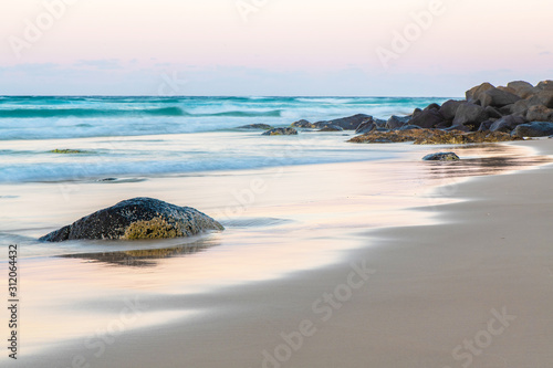 Fotografia stone on beach at sunrise