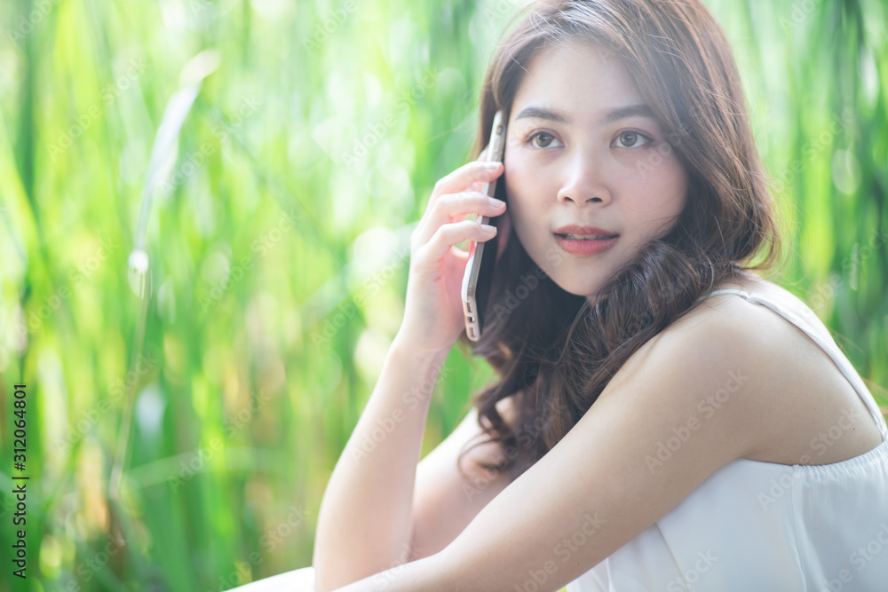 Beautiful smiling women use smartphone while leisure in city freen park Beautiful smiling women use smartphone while leisure in city freen park