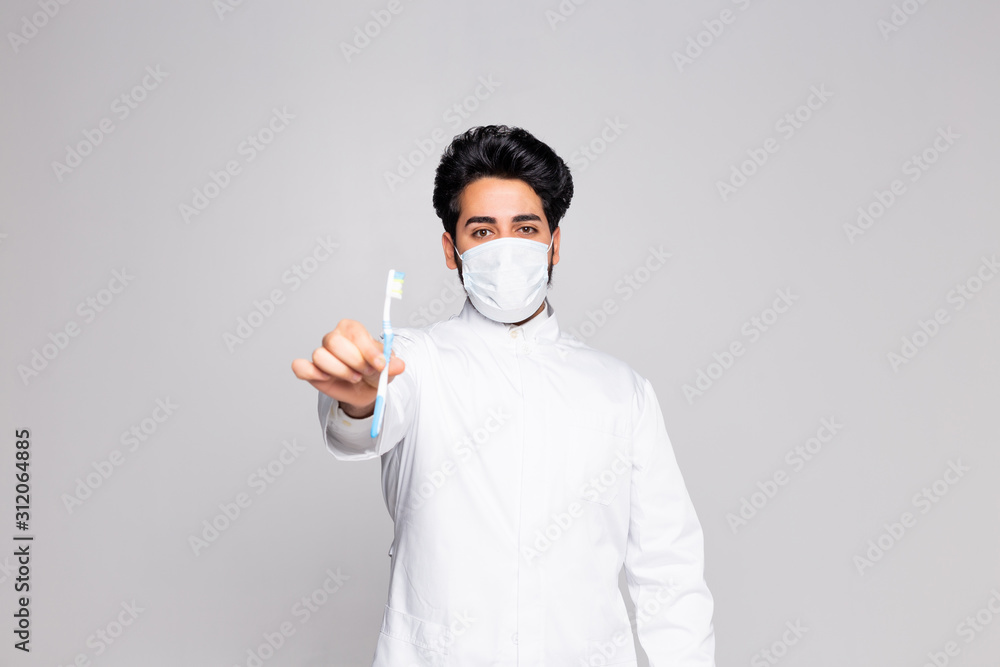 Portrait of handsome young dentist teaching a patient to brush teeth, isolated against white background Portrait of handsome young dentist teaching a patient to brush teeth, isolated against white background