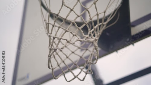 Basketball net at outdoor park, close up footage camera with shallow depth of field and gimbal moving slowly. Tuned colors.