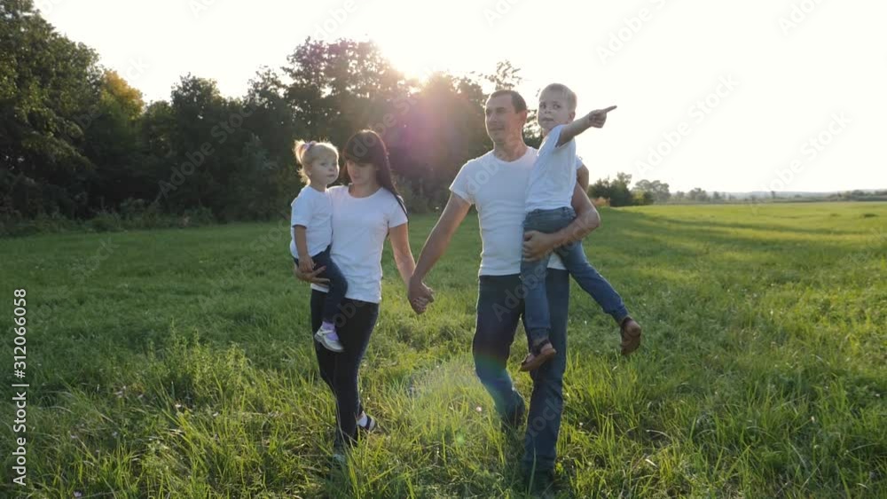 Happy young family walking together in the fresh air. A couple with children have fun in a green Park, enjoying the beautiful clean nature. Happy young family walking together in the fresh air. A couple with children have fun in a green Park, enjoying the beautiful clean nature.