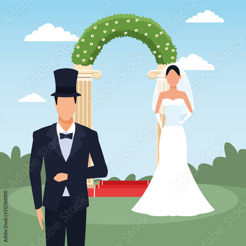 Groom and bride standing over floral arch and landscape background