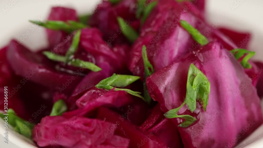 Fermented cabbage with beets and green onions rotates clockwise, top view, close-up Fermented cabbage with beets and green onions rotates clockwise, top view, close-up