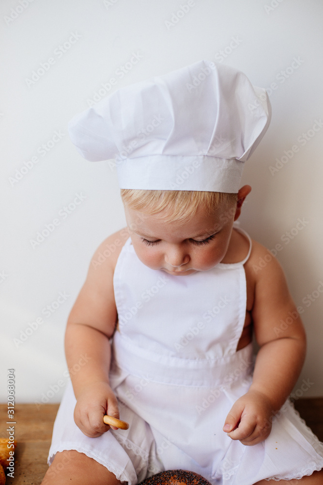 Little boy in a cook suit with buns Little boy in a cook suit with buns