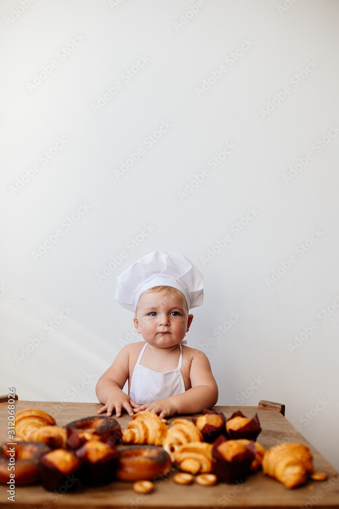 Little boy in a cook suit with buns Little boy in a cook suit with buns