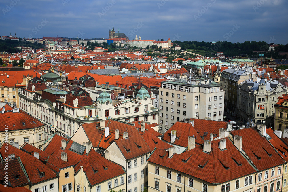 view of the red roofs of Mala Strana and St. Vitus Cathedral in Prague, Czech Republic.