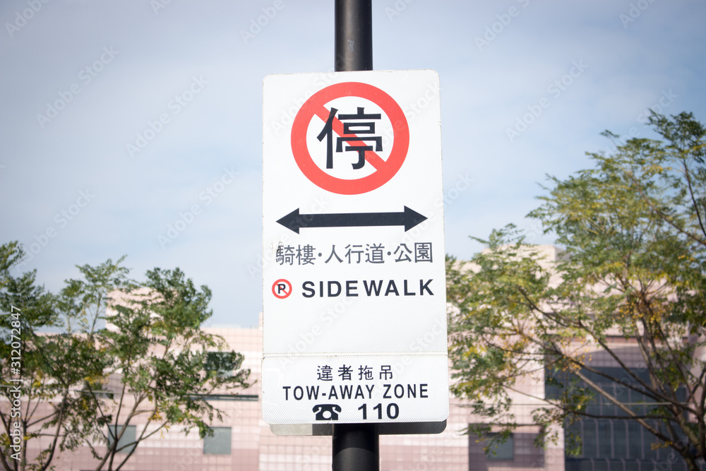 The image of stop sign in the park in Taipei, Taiwan. Translation : stop, veranda, footwalk, park and offender towing.