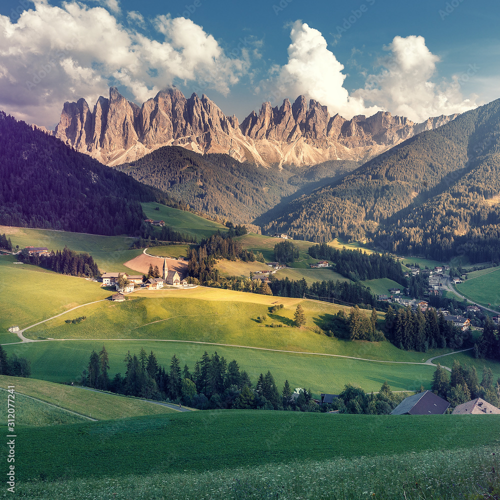 Wonderful nature Landscape. Val di Funes, Trentino Alto Adige, Italy. The great autumnal colors shines under the late sun with Odle on the background and Santa Magdalena Village on the foreground.