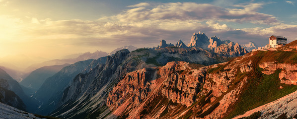 Wonderful Sunny Landscape of Dolomite Alps during sunrise. Panoramic view of famous Dolomites mountain peaks glowing in beautiful golden evening light at sunset in summer, South Tyrol, Italy.
