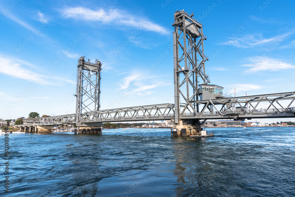Vertical lift bridge spanning a river on a clear autumn day Vertical lift bridge spanning a river on a clear autumn day