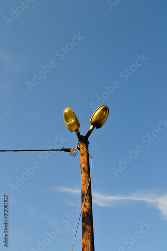 Old wooden pole with two blurry street light connected with cable. photo