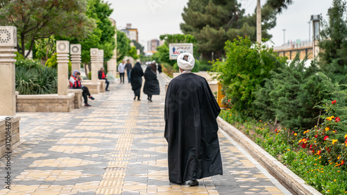Iranian man walking in a street in the sacred city of Qom, Iran photo