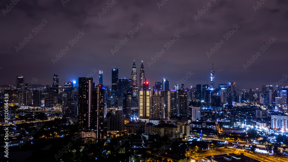 Night view of Kuala Lumpur city skyline with illuminated Petronas twin towers