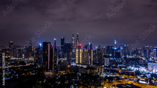 Night view of Kuala Lumpur city skyline with illuminated Petronas twin towers