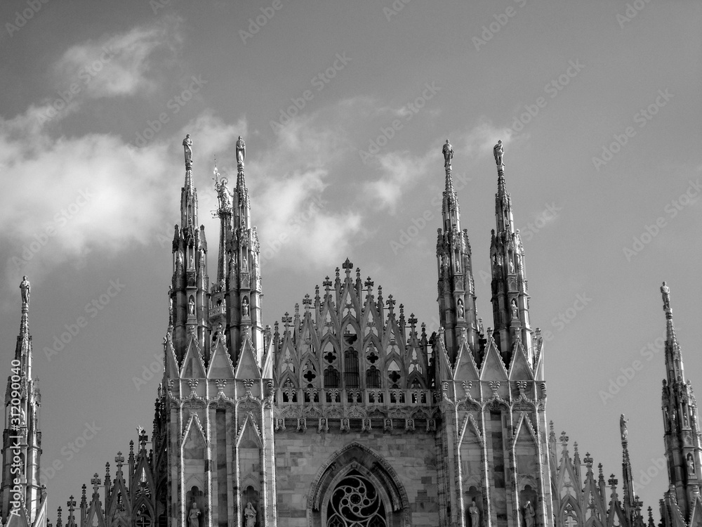 Milan, Italy - 12/25/2019: An amazing caption of the Duomo of Milan in winter days with some people enjoying the evening and beautiful black and white background, and beautiful photo of some skylines