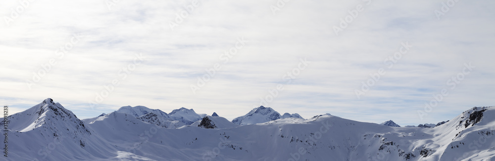 Panorama of high winter mountains with snowy slopes