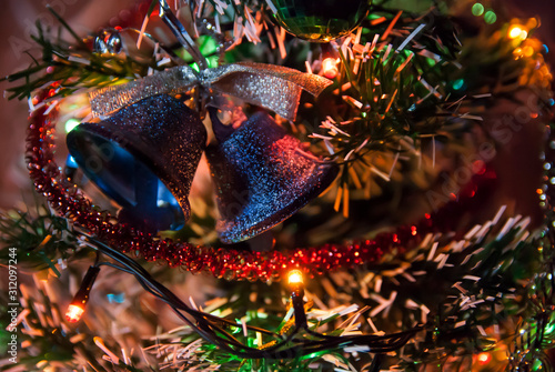 bells and a sparkling garland on a Christmas tree.