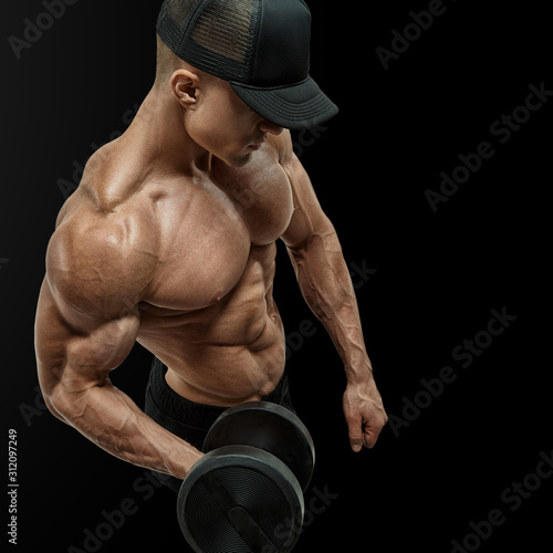 Obraz na plátně Closeup of a handsome power athletic man bodybuilder doing exercises with dumbbell in left hand