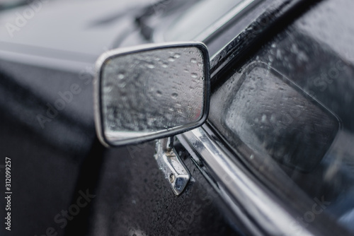 Car side view mirror with rain drops