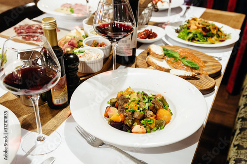 served table in the restaurant for a banquet with appetizers, salads and wine