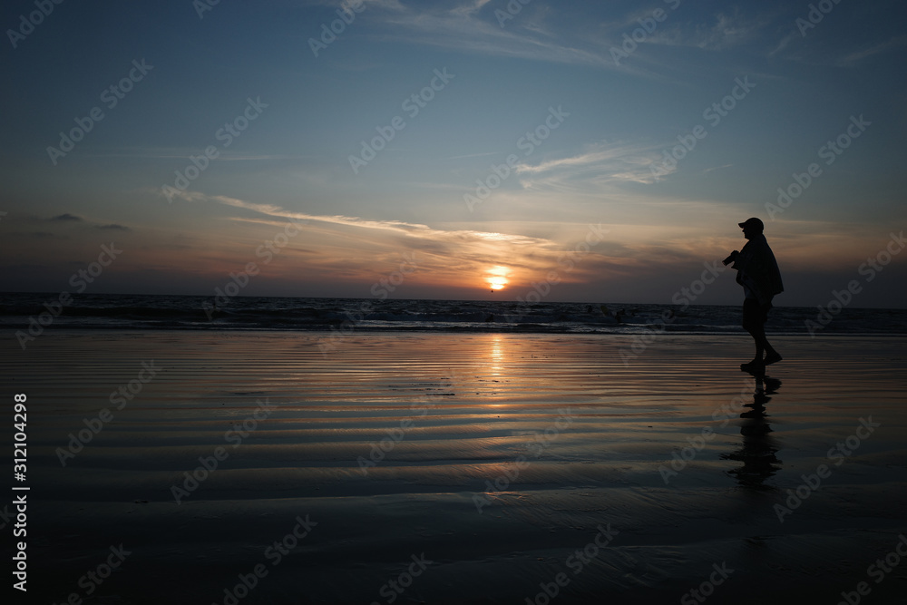 A man photographs the sunset. 