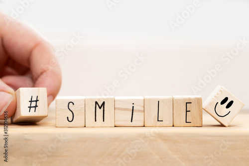 Wooden cubes with a Hashtag and the word smile, social media concept background