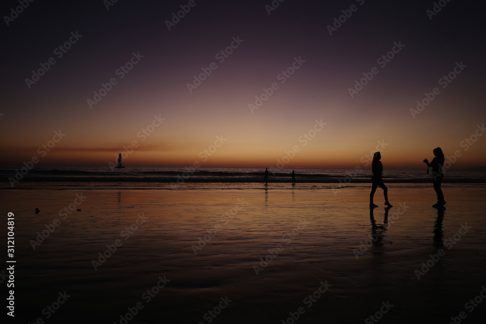 Fototapeta premium People on the beach at sunset. 