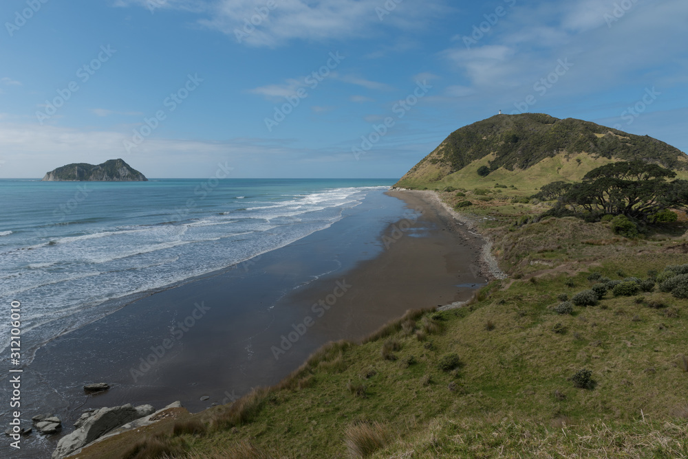 The northern coast of East Cape, New Zealand, with the lighthouse on Otiki Hill in the background, and East Island just off shore.