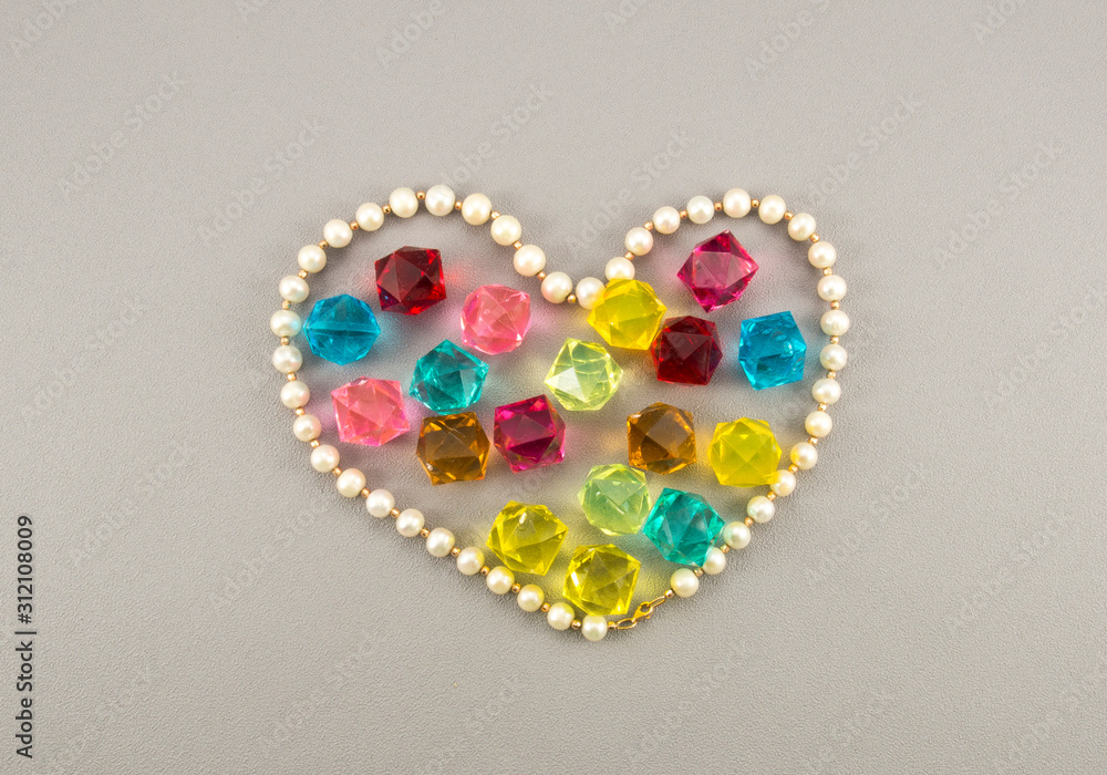 White pearl heart with gems on gray background White pearl heart with gems on gray background