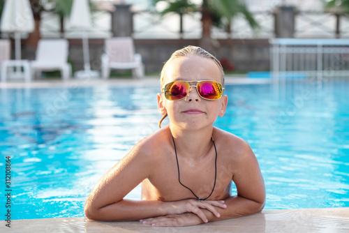 boy in sunglasses in the pool. concept of travel, summer, vacation, recreation and childhood