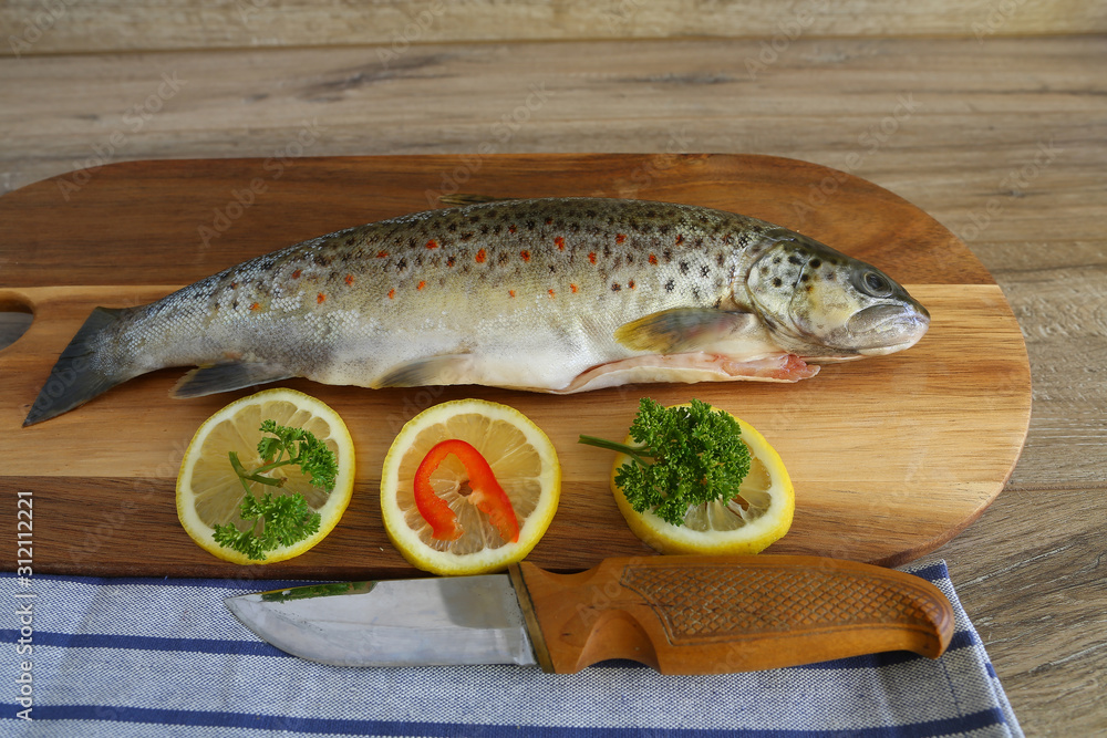 Fresh trout with spices and seasoning on cutting board Fresh trout with spices and seasoning on cutting board