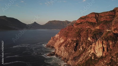 4K high quality aerial sunny afternoon sunset footage of spectacular scenic Chapman's Peak Drive, rocky mountains, Atlantic Ocean between Hout Bay, Noordhoek in Western Cape, Cape Town, South Africa
