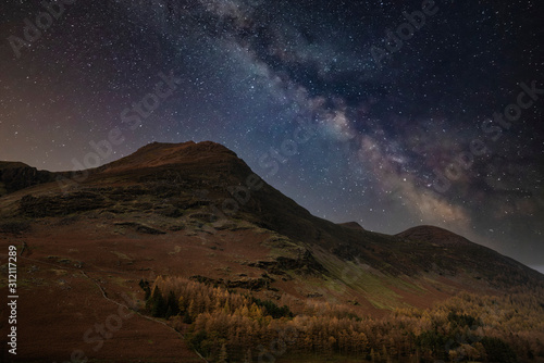Stunning majestic digital composite landscape of Milky Way over Buttermere in Lake District