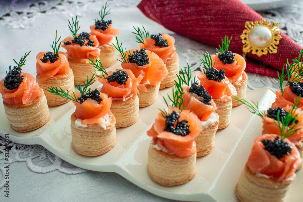 salmon canape with black caviar on plate Photos | Adobe Stock