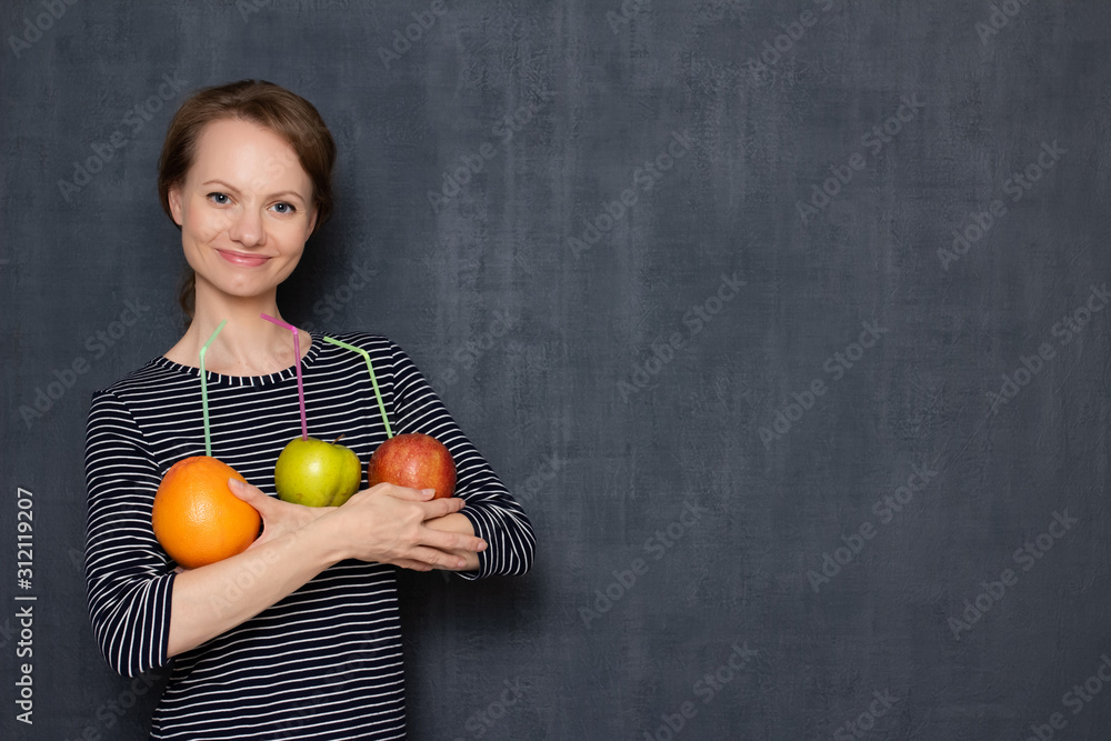 Portrait of happy girl holding fruits with drinking straws inserted Portrait of happy girl holding fruits with drinking straws inserted