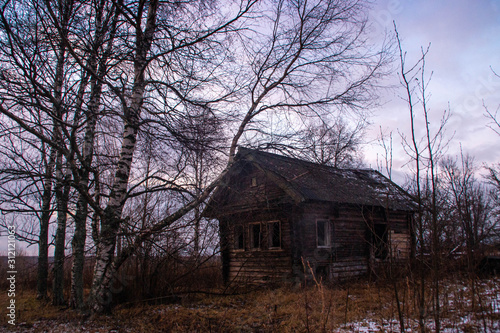 Abandoned house in a small Russian village at sunset