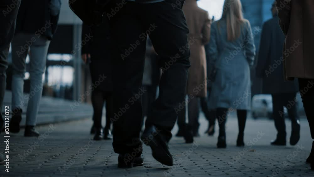 Close Up Leg Shot of a Business People Commuting to the Office on Foot. Managers and Businessmen Walk on a Crowded Pedestrian Street. Cloudy Day in Downtown. Close Up Leg Shot of a Business People Commuting to the Office on Foot. Managers and Businessmen Walk on a Crowded Pedestrian Street. Cloudy Day in Downtown.
