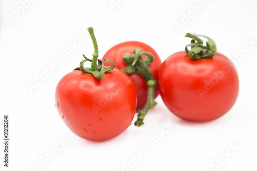 ripe fresh organic tomatoes in drops of dew isolated on white background © fotodiya83