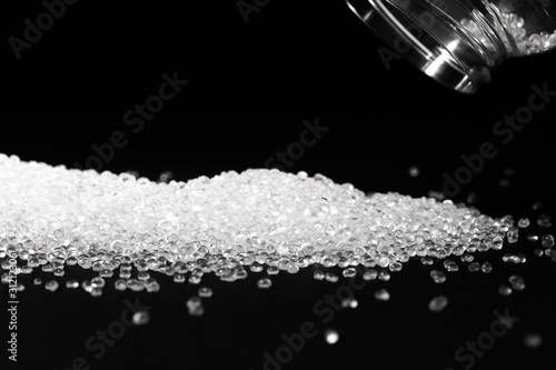 Transparent polypropylene granules plastic pellets material on black background photo