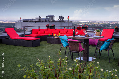 View of city from the rooftop terrace. Relax zone with furniture and jacuzzi.