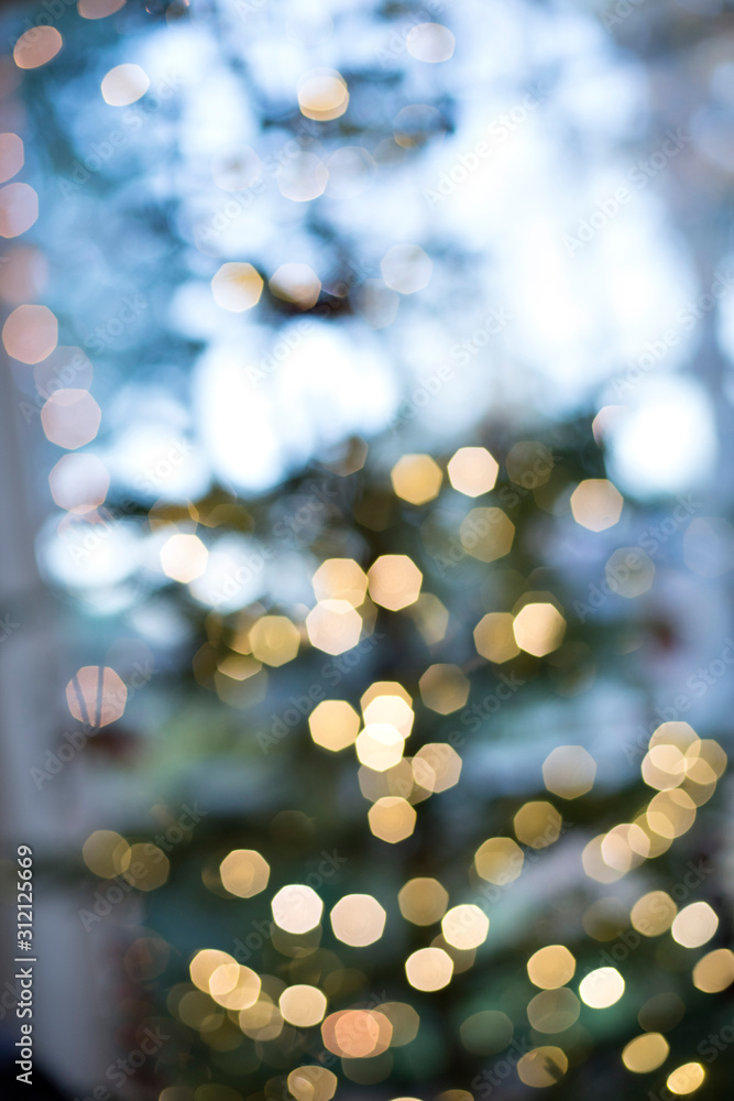 Lit Christmas Tree not in focus and with yellow lights with bokeh effect - Abstract concept for holidays