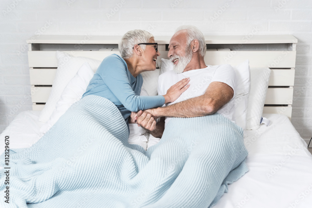 Senior couple lying in bed together Senior couple lying in bed together