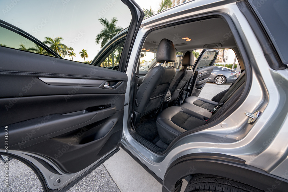 Rear passenger door open to a car or suv vehicle with dark interior seats Rear passenger door open to a car or suv vehicle with dark interior seats