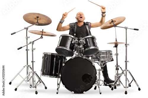 Male musician in leather vest playing a drum kit