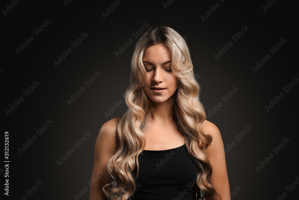 Beautiful young woman with curly hair on dark background Beautiful young woman with curly hair on dark background