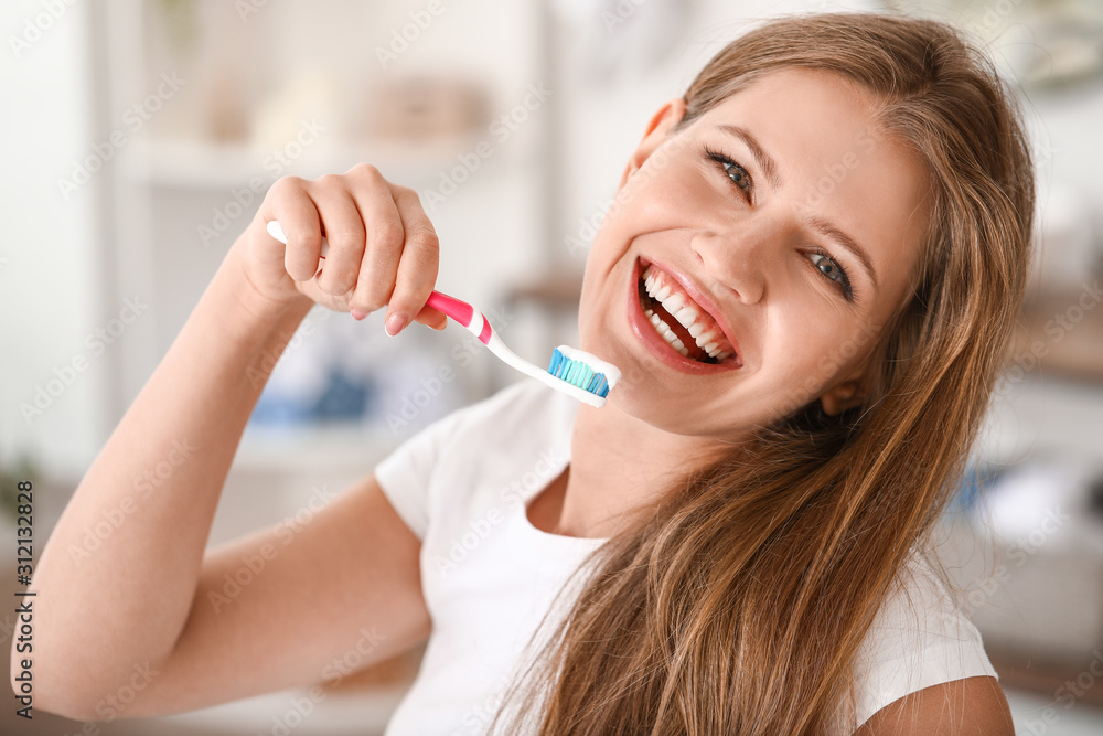 Young woman brushing teeth at home Young woman brushing teeth at home