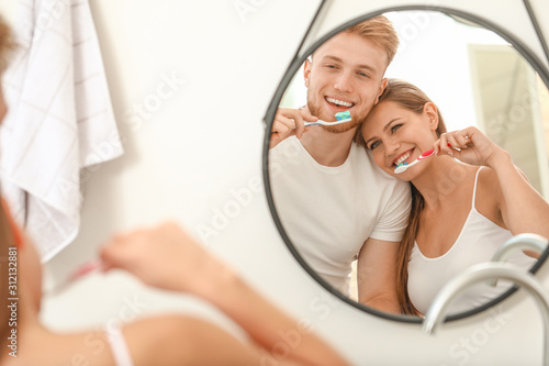 Young couple brushing teeth at home